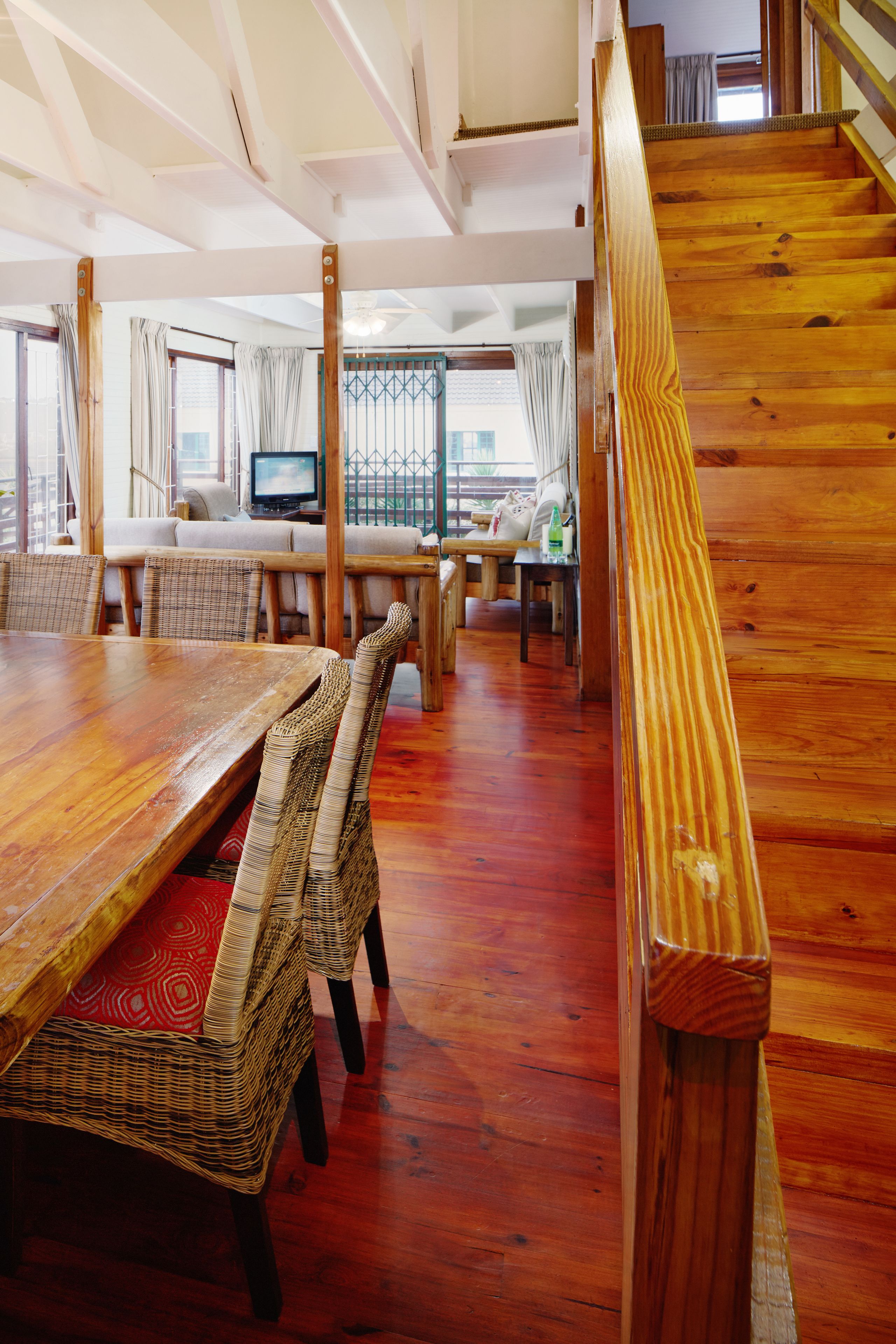 A wooden staircase leading to a balcony with a view.