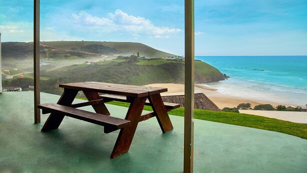 A picnic table with a view of the beach and ocean. - First Group Hole in the Wall (King Sabata Dalindyebo)