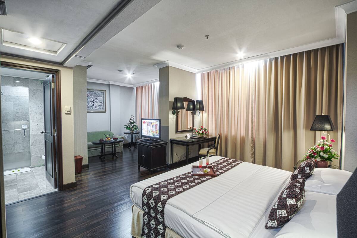 Une chambre d’hôtel avec un lit, un bureau, une télévision et une salle de bain.