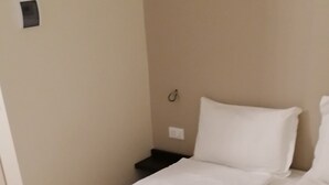 A single-bed room with a wooden floor, white bedding, and a small bedside table. - Hotel Boccascena (Genoa)
