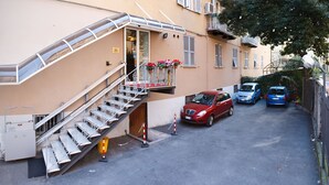 A narrow street with a staircase leading to a building entrance. There are three cars parked along the street. - Hotel Boccascena (Genoa)