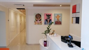 A hotel reception area with a modern design, including a reception desk, a plant, and artwork on the wall. - Hotel Boccascena (Genoa)