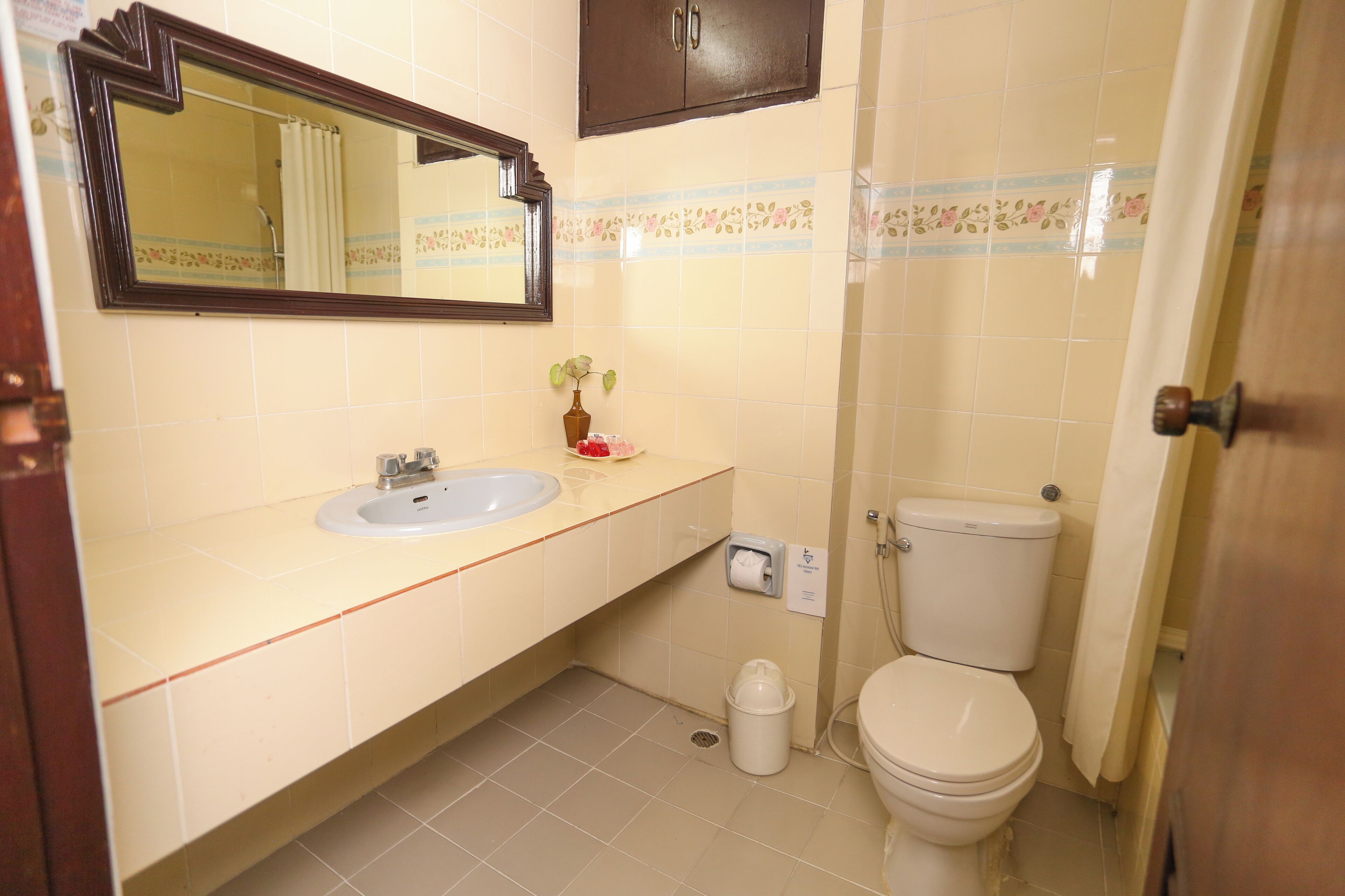 A bathroom with a sink, mirror, toilet, and a cabinet.