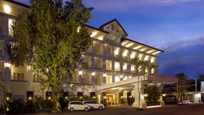 A multi-story hotel with a grand entrance, large windows, and a well-lit facade. - Gallery Prawirotaman Hotel (Yogyakarta)