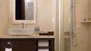 Un baño moderno con un lavabo grande, un espejo, una ducha y un perchero para toallas.