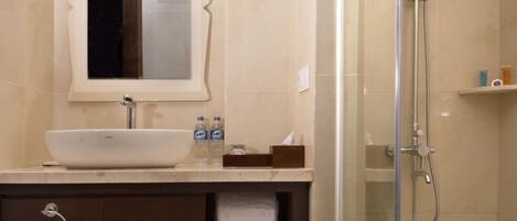 Un baño moderno con un lavabo grande, un espejo, una ducha y un perchero para toallas.