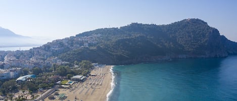 On the beach, sun-loungers, beach umbrellas, beach bar