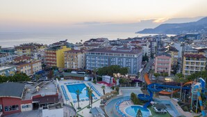 A hotel with a pool area, including a water slide and a children's play area. - Aslan City Hotel (Alanya)