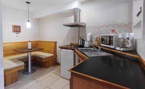 A compact kitchen with a built-in microwave, coffee maker, and a sink. - Aires del Beagle (Ushuaia)