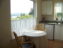 Una cocina pequeña con vista al exterior, una mesa con una silla y una ventana con vistas.