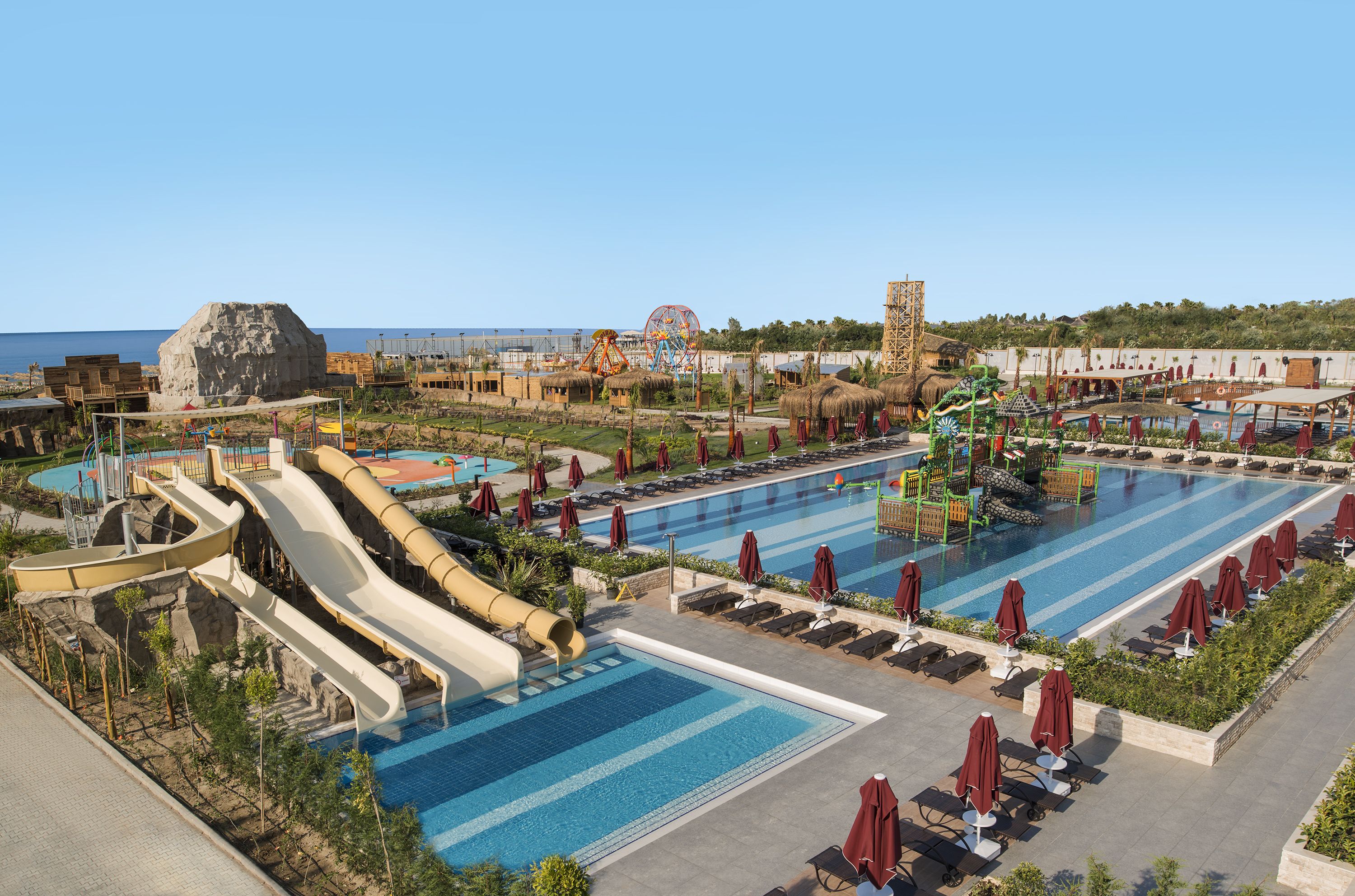 A resort with a large pool, water slides, and a Ferris wheel.