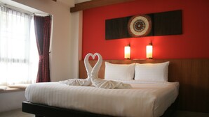 A neatly made bed with white linens and two heart-shaped pillows. - Baan Ing Ping (Chiang Mai)