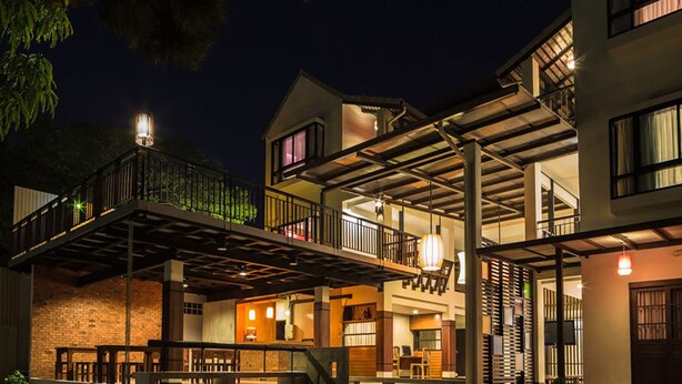 A multi-story building with a covered outdoor area, a staircase, and a balcony. - Baan Ing Ping (Chiang Mai)