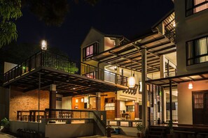 A multi-story building with a covered outdoor area, a staircase, and a balcony. - Baan Ing Ping (Chiang Mai)