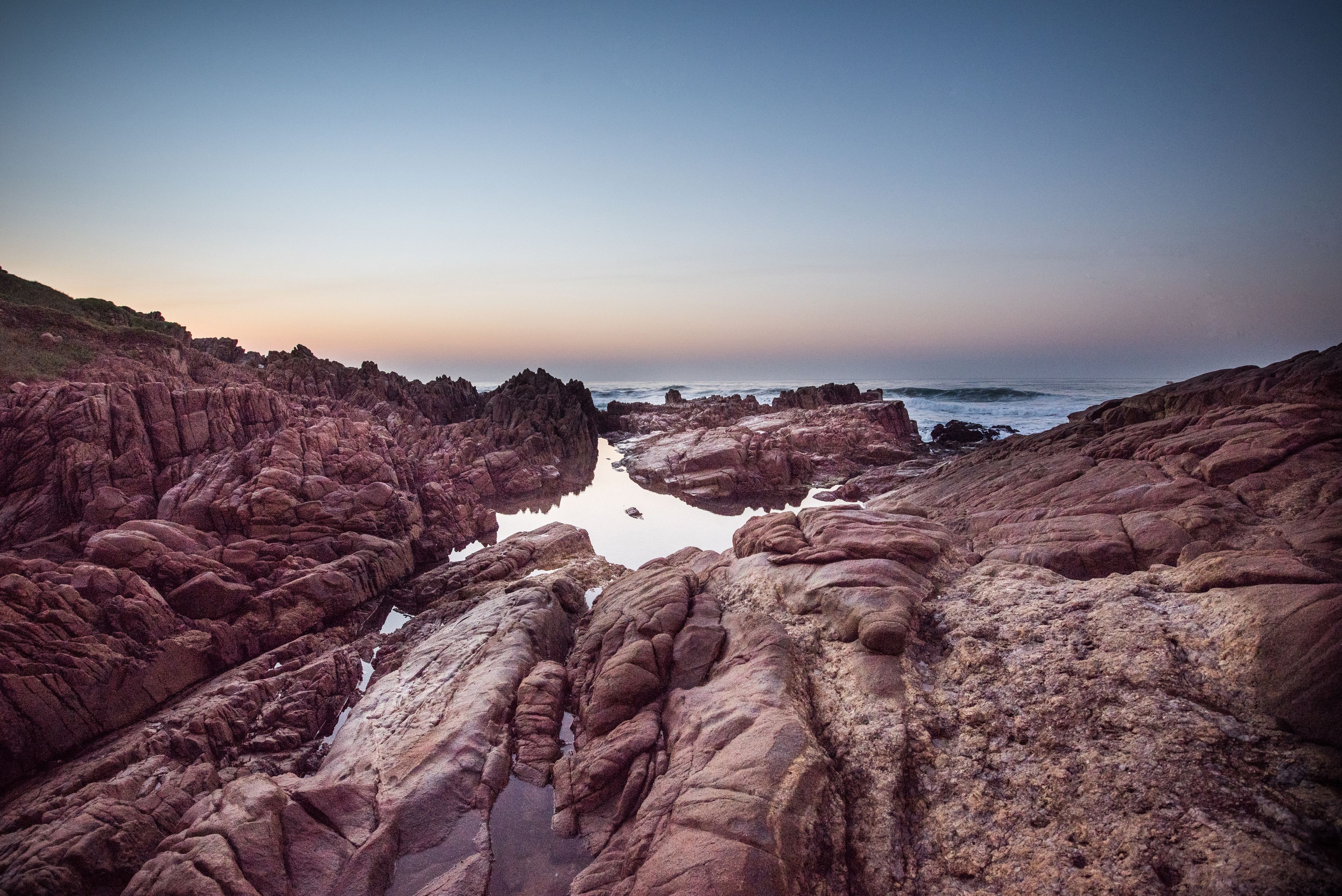 A rocky coastal landscape with a clear sky.