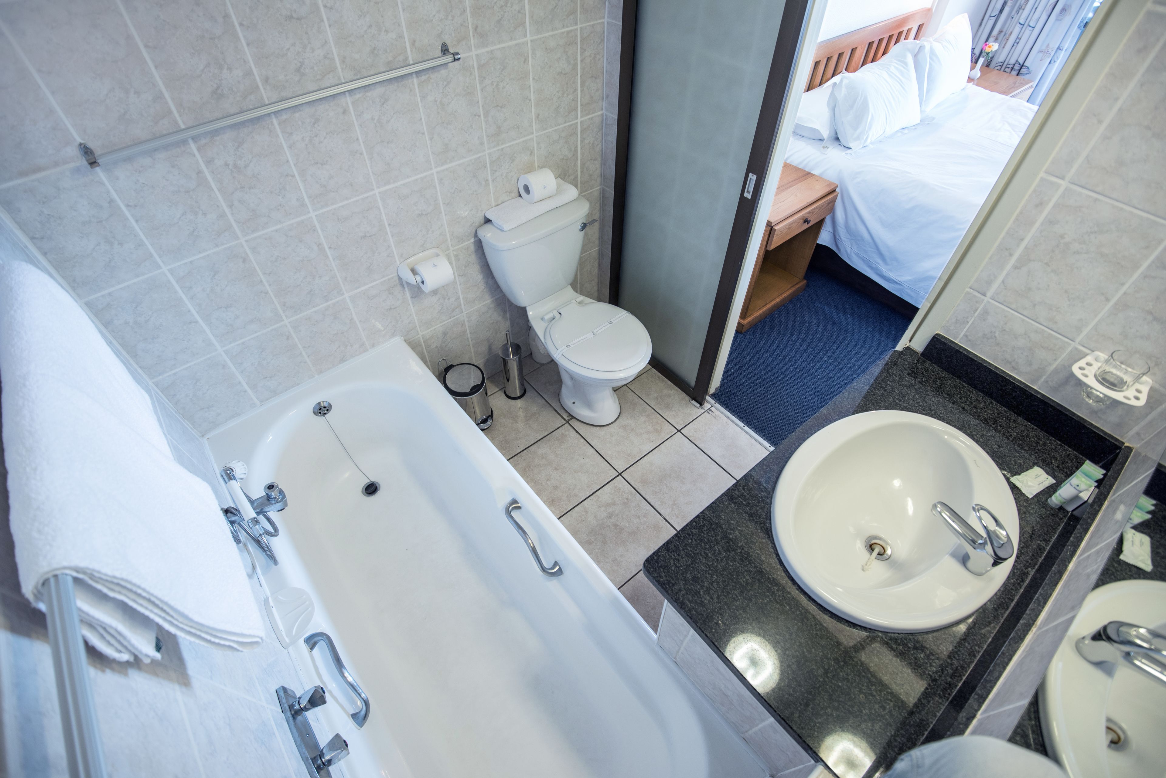 A modern bathroom with a bathtub, toilet, and sink.