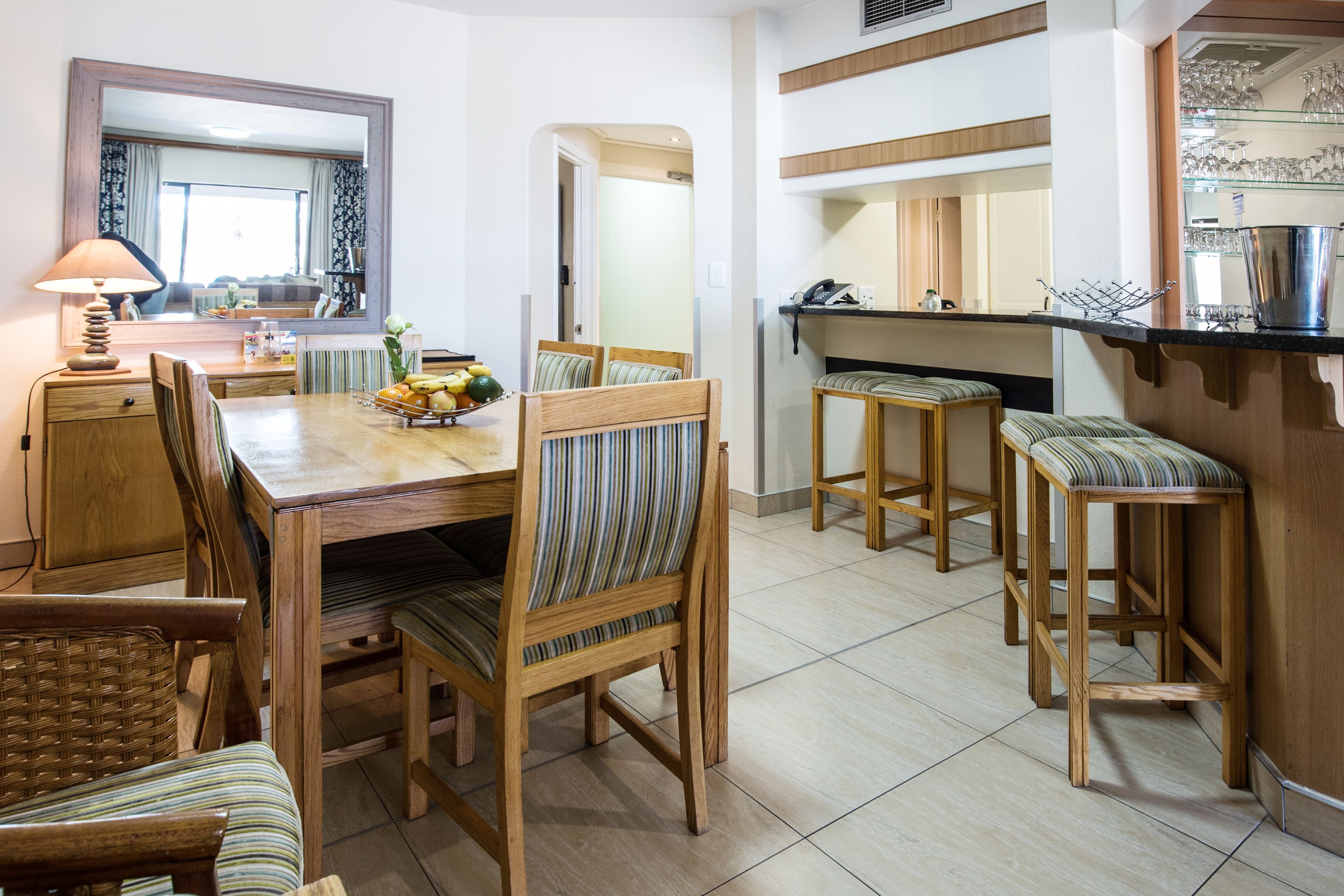Zona pranzo con tavolo in legno, sedie e buffet.