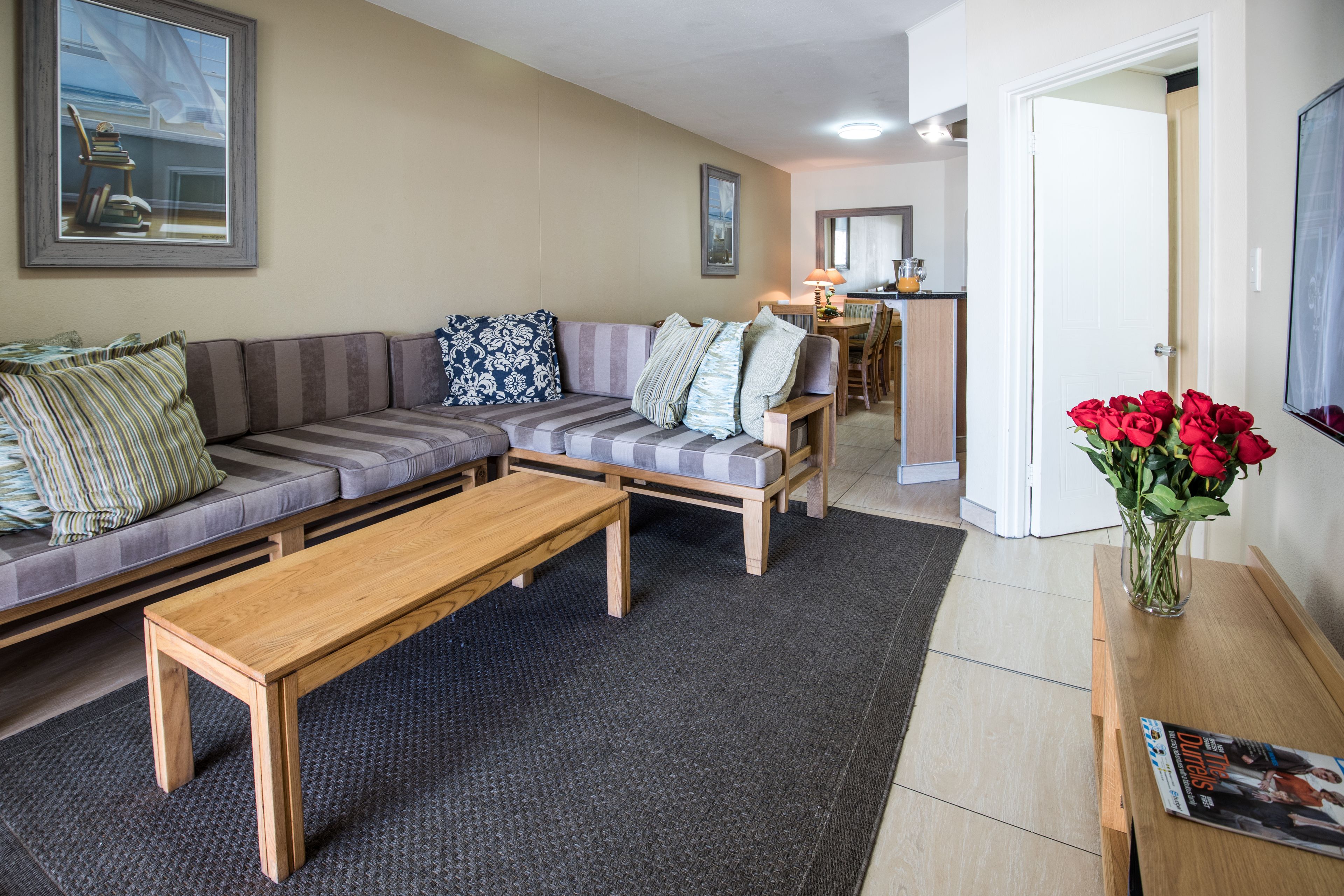 Een woonkamer met een bank, een salontafel en een eethoek met stoelen en een tafel.