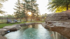 A natural pool with a wooden deck and lounge chairs, surrounded by a wooden fence and trees. - Whispering Waters (Nottingham Road)