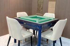 Una mesa con un juego de mesa, cuatro sillas y un muro de madera.