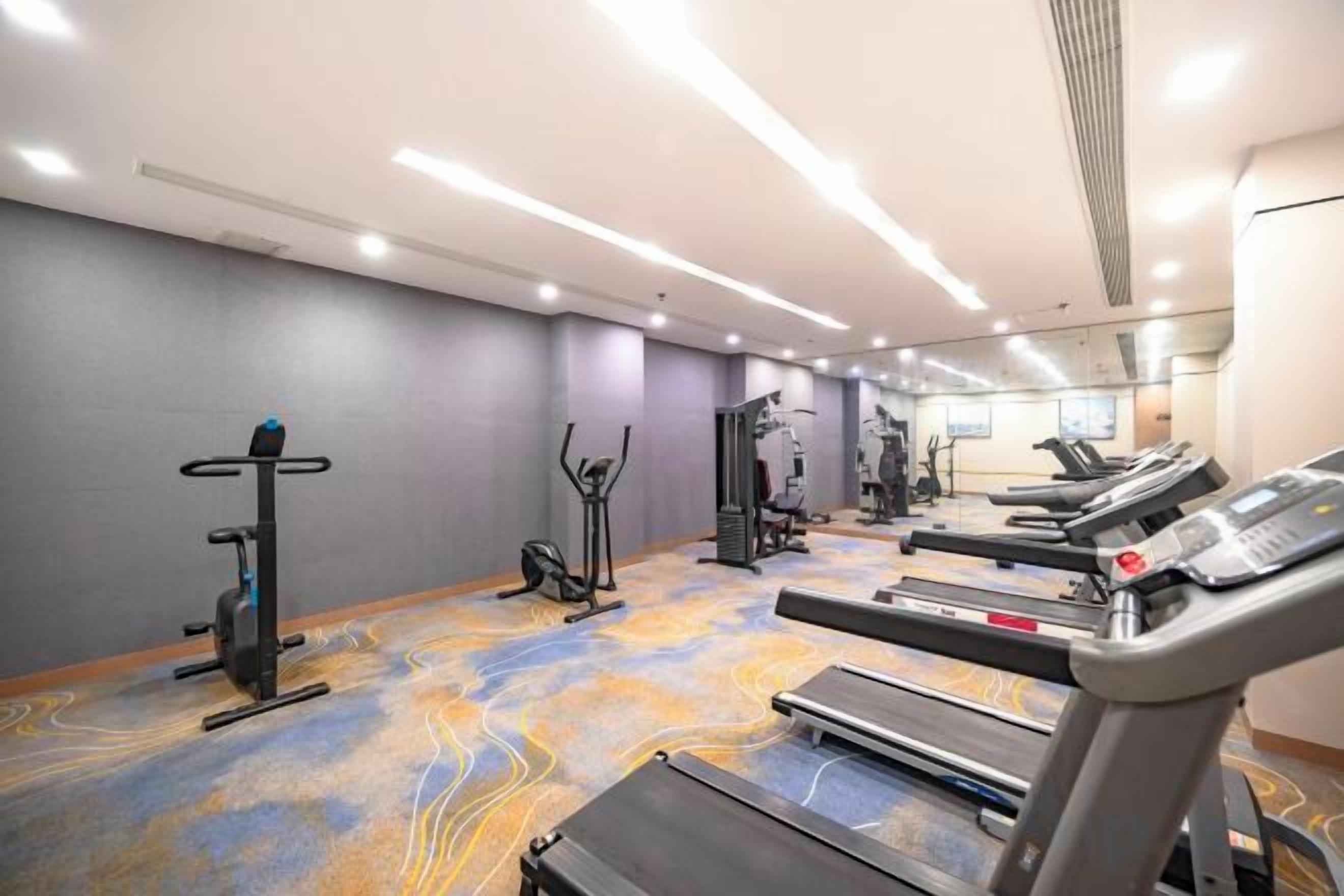A gym with treadmills, elliptical machines, and weight equipment.