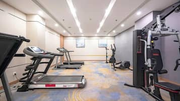 Una palestra alberghiera con tapis roulant, macchinari ellittici e attrezzature per l'allenamento con i pesi.