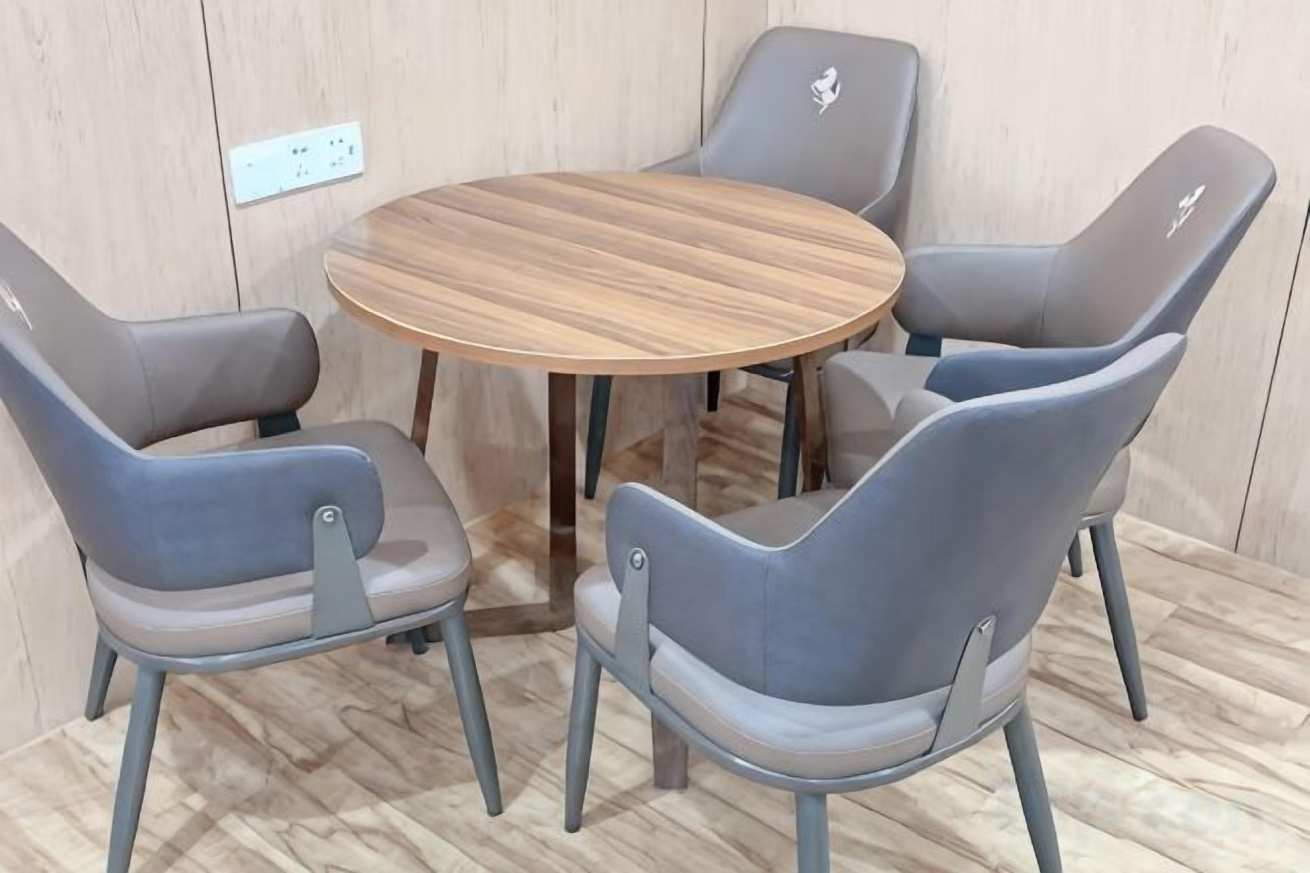 A round table with four grey chairs around it.
