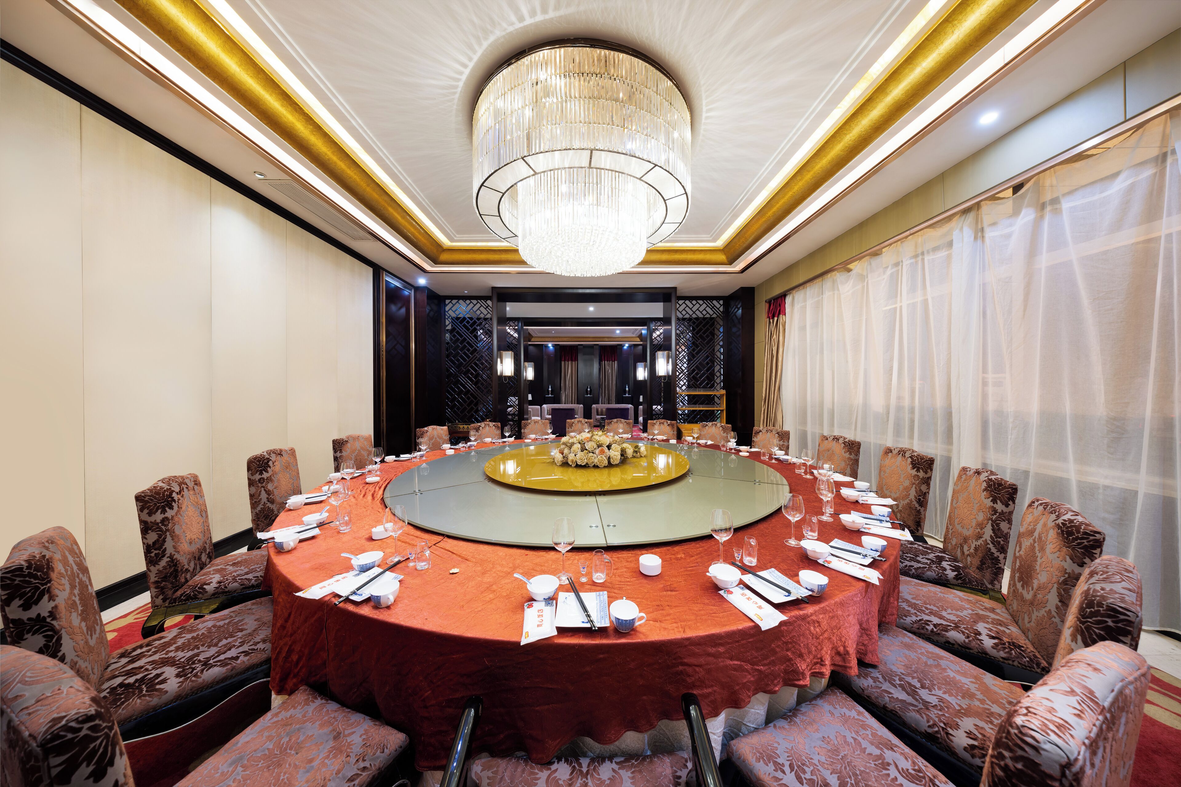 Une salle de conférence équipée d’une table ronde, de chaises et d’un lustre.