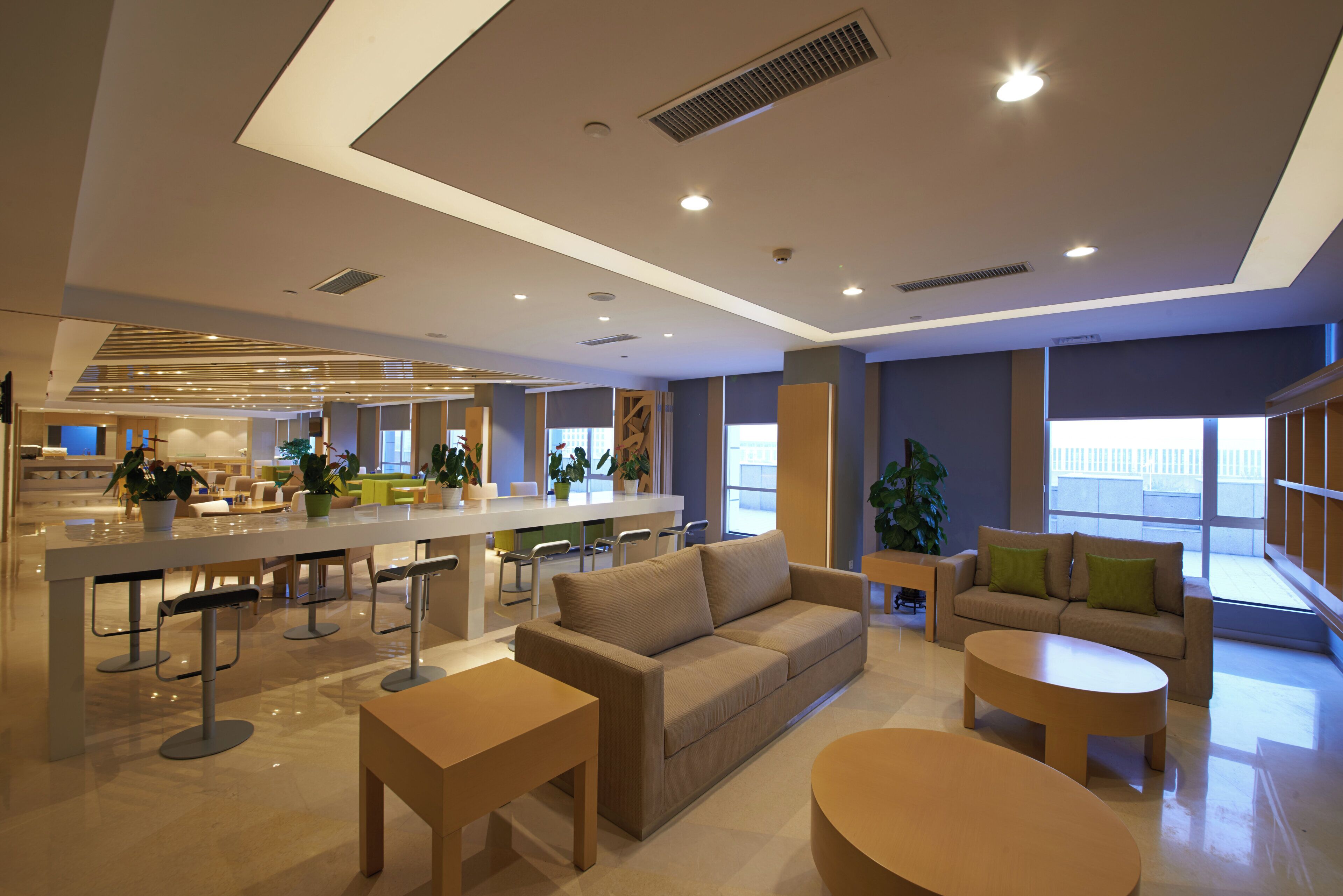 A modern interior with a bar area, seating, and large windows.
