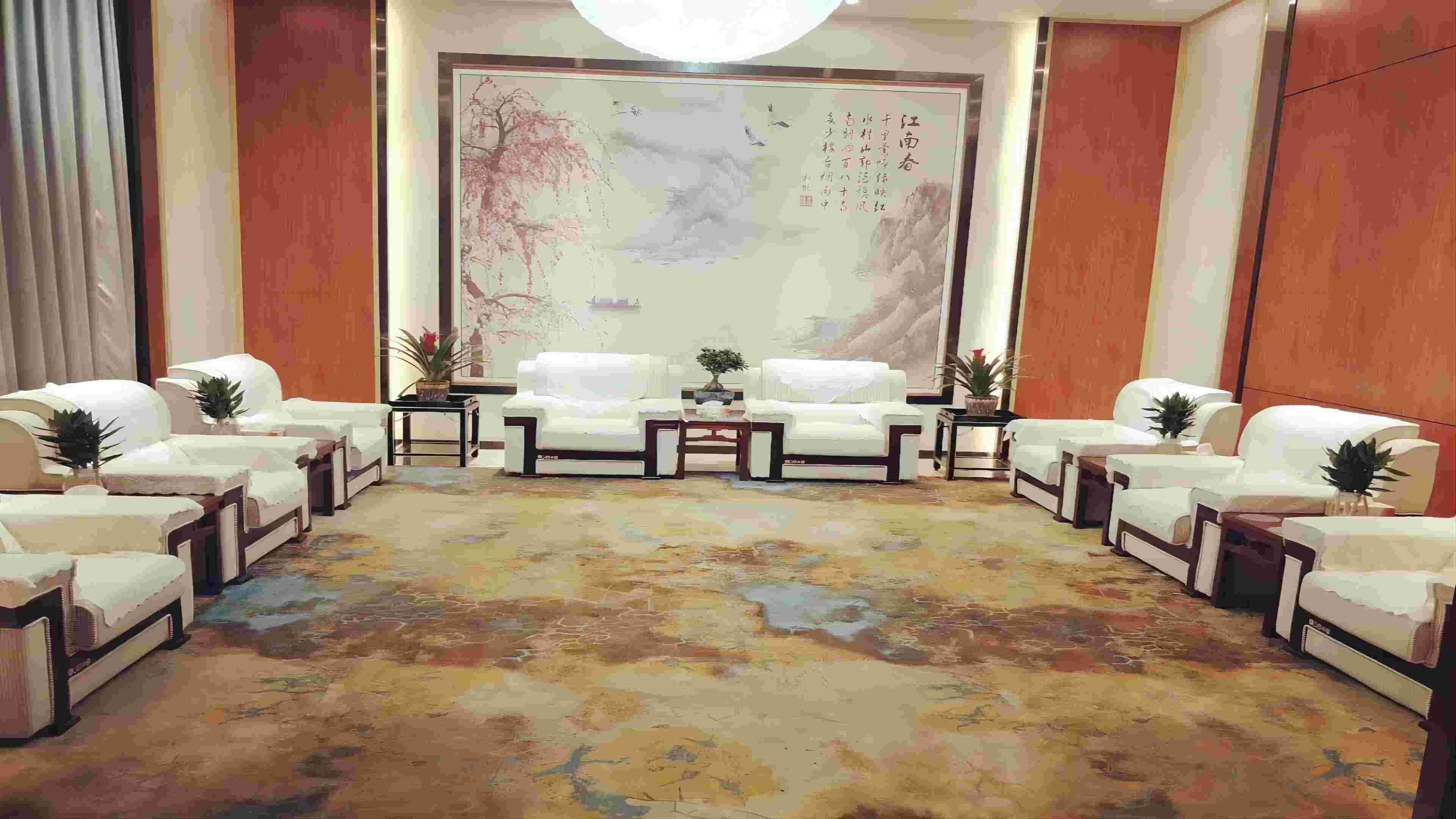 Una habitación con un cuadro tradicional de gran tamaño, dos sofás, una mesa de centro y una alfombra estampada.