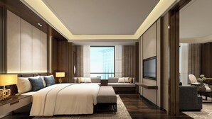 Een moderne hotelkamer met een groot bed, een bank, een televisie en een bureau.