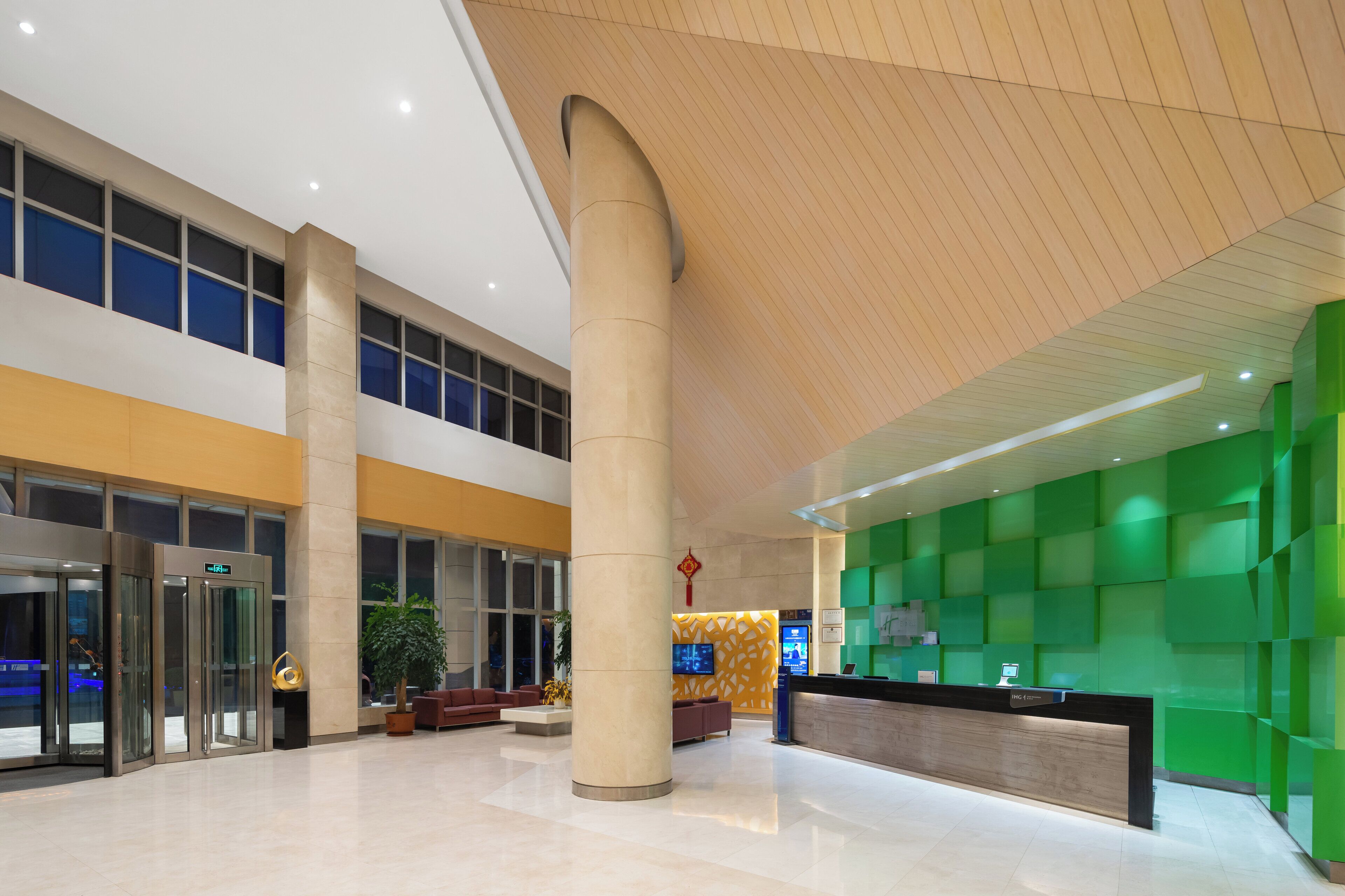 Un hall d’entrée spacieux, doté d’un comptoir de réception, d’une grande colonne et d’un design de plafond moderne.