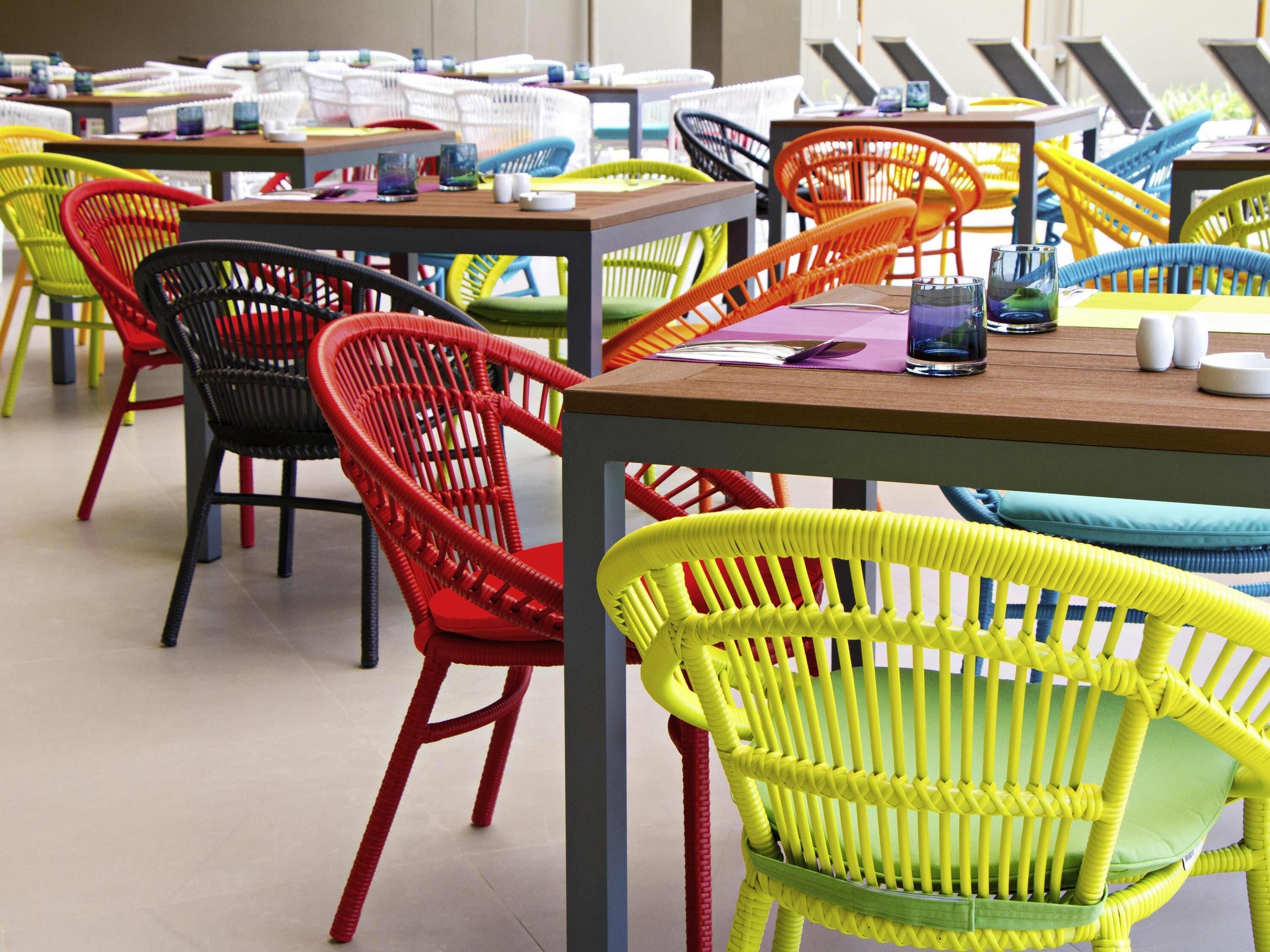 A room with multiple tables and chairs, each with a unique woven design.