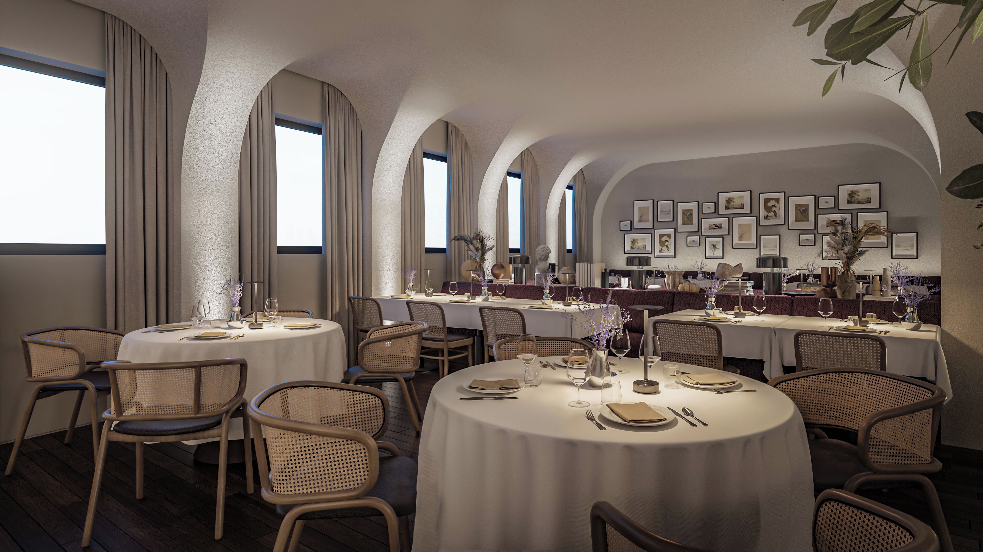 A restaurant with round tables, wicker chairs, and a wall of framed pictures.