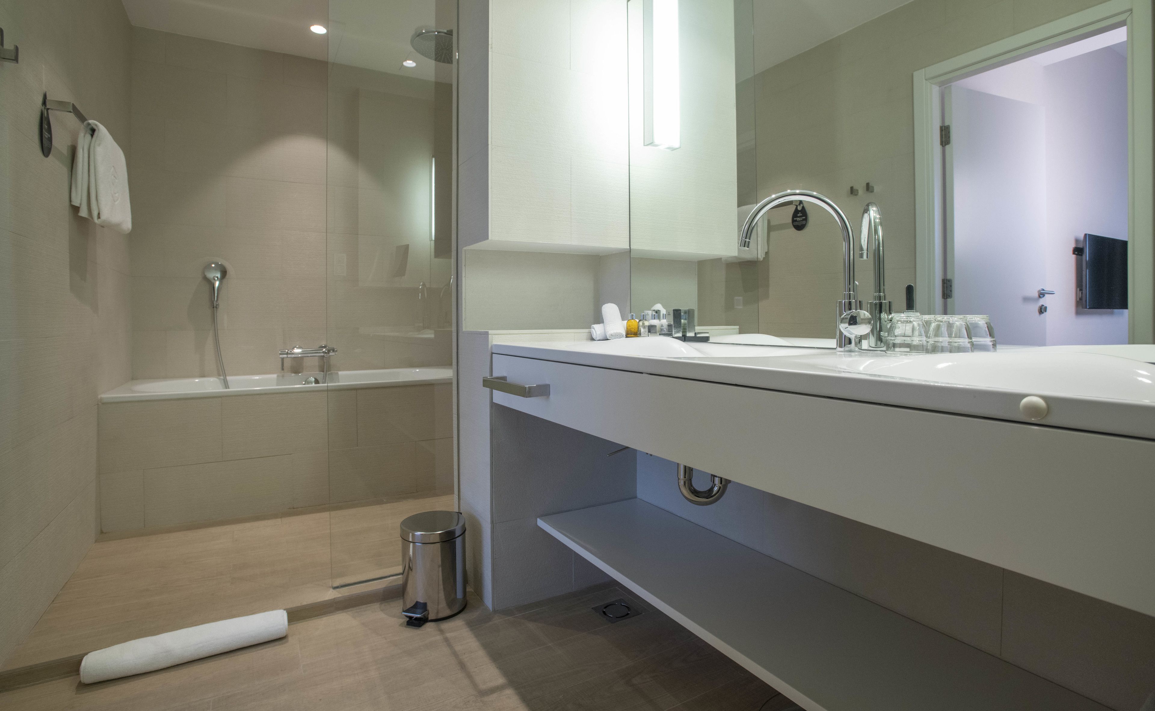 Un baño moderno con una bañera, un lavabo y un espejo.