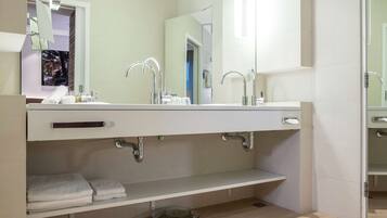 Un bagno moderno con un ampio specchio, due lavabi e un portasciugamani.