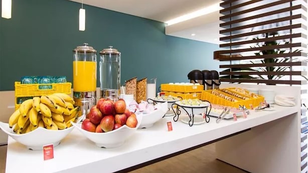 En morgenmadsbuffet med forskellige frugter, juice og morgenmadsprodukter.