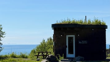 A small stone building with a door and a sign reading 'The Cove The Grotto.'