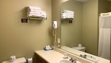 A bathroom with a sink, mirror, and towel rack.