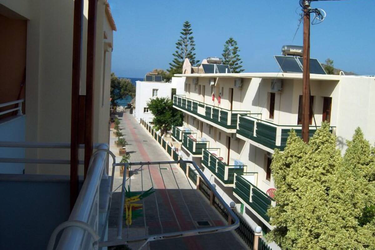 Ein mehrstöckiges Hotel mit Balkonen, freier Straßenansicht und einem Gebäude mit grüner Fassade.
