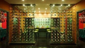 A wine cellar with shelves of wine bottles and a central seating area.