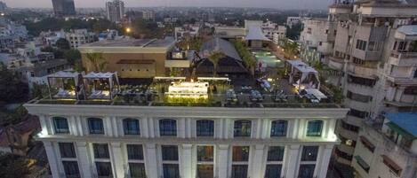 Un hôtel doté d’une terrasse sur le toit, comprenant un espace extérieur aménagé et une piscine.