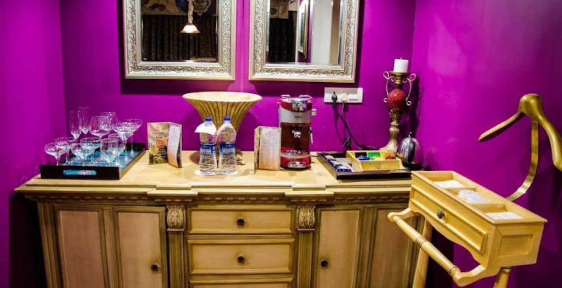 A bar area with a counter, glasses, bottles, and a coffee machine.