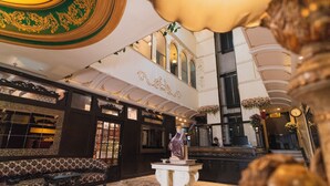 A grand lobby with ornate ceiling designs, a statue on a pedestal, and a seating area with patterned sofas. - The Nagpur Ashok (Nagpur)