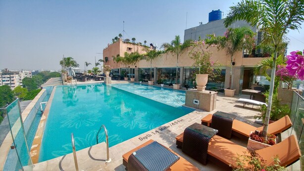 A rooftop pool with a depth of 1.4 meters, surrounded by lounge chairs and potted plants. - The Nagpur Ashok (Nagpur)