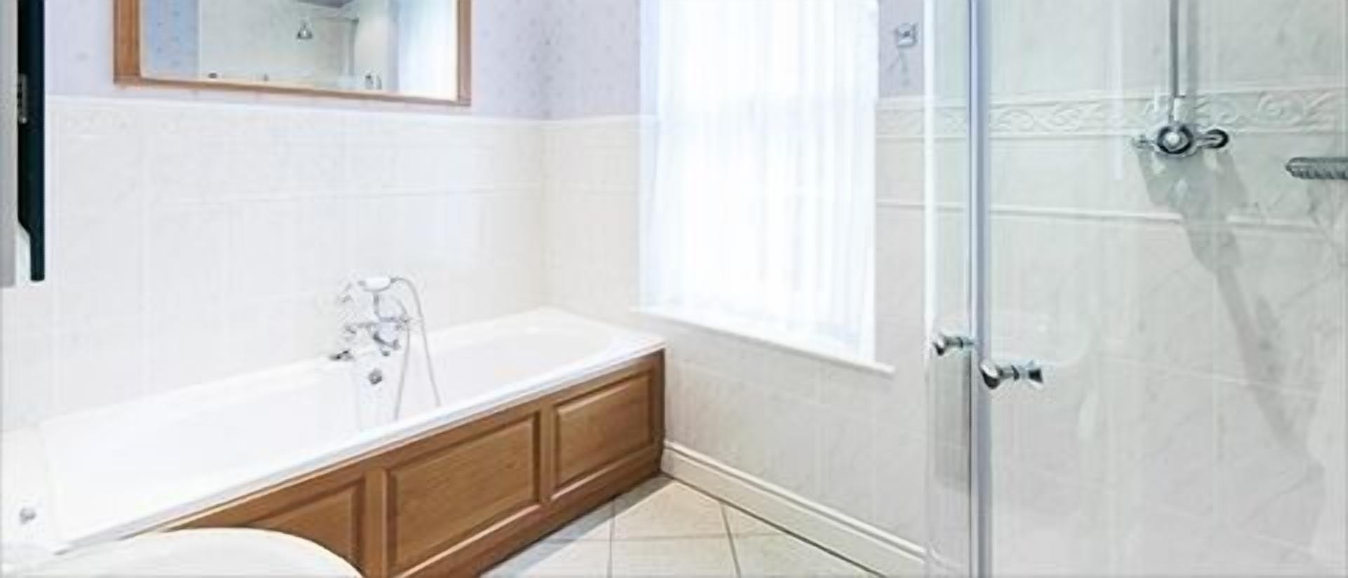 A bathroom with a bathtub, a shower, and a window.