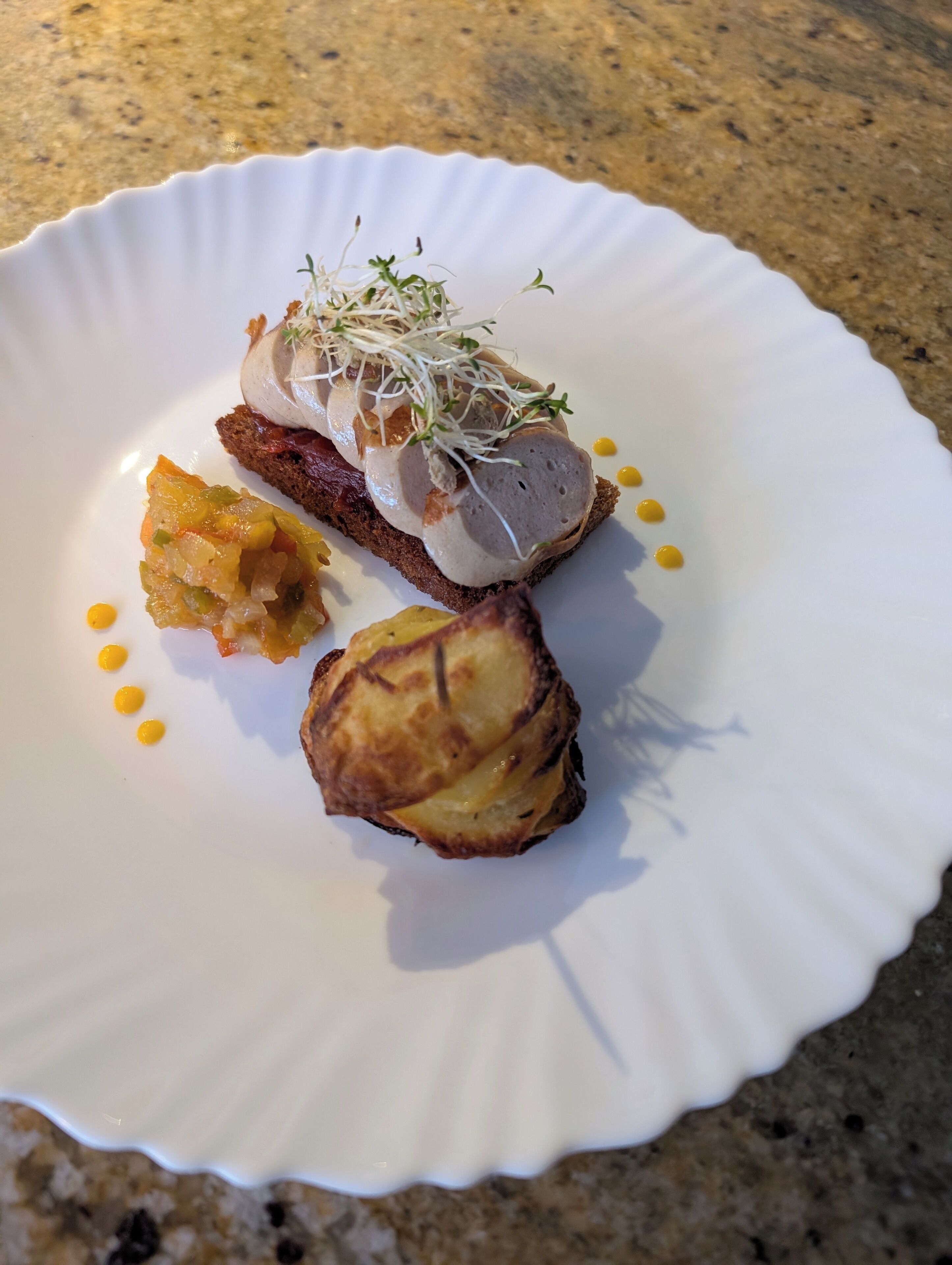 A white plate with a slice of bread topped with a meat patty, sprouts, and a side of pickled vegetables.