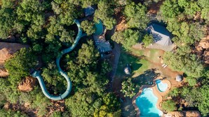 Vue aérienne d’un complexe hôtelier doté d’un bassin sinueux, d’une piscine et d’un kiosque.