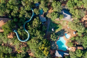 Vista aérea de un resort con una fuente serpenteante, piscina y un pabellón.