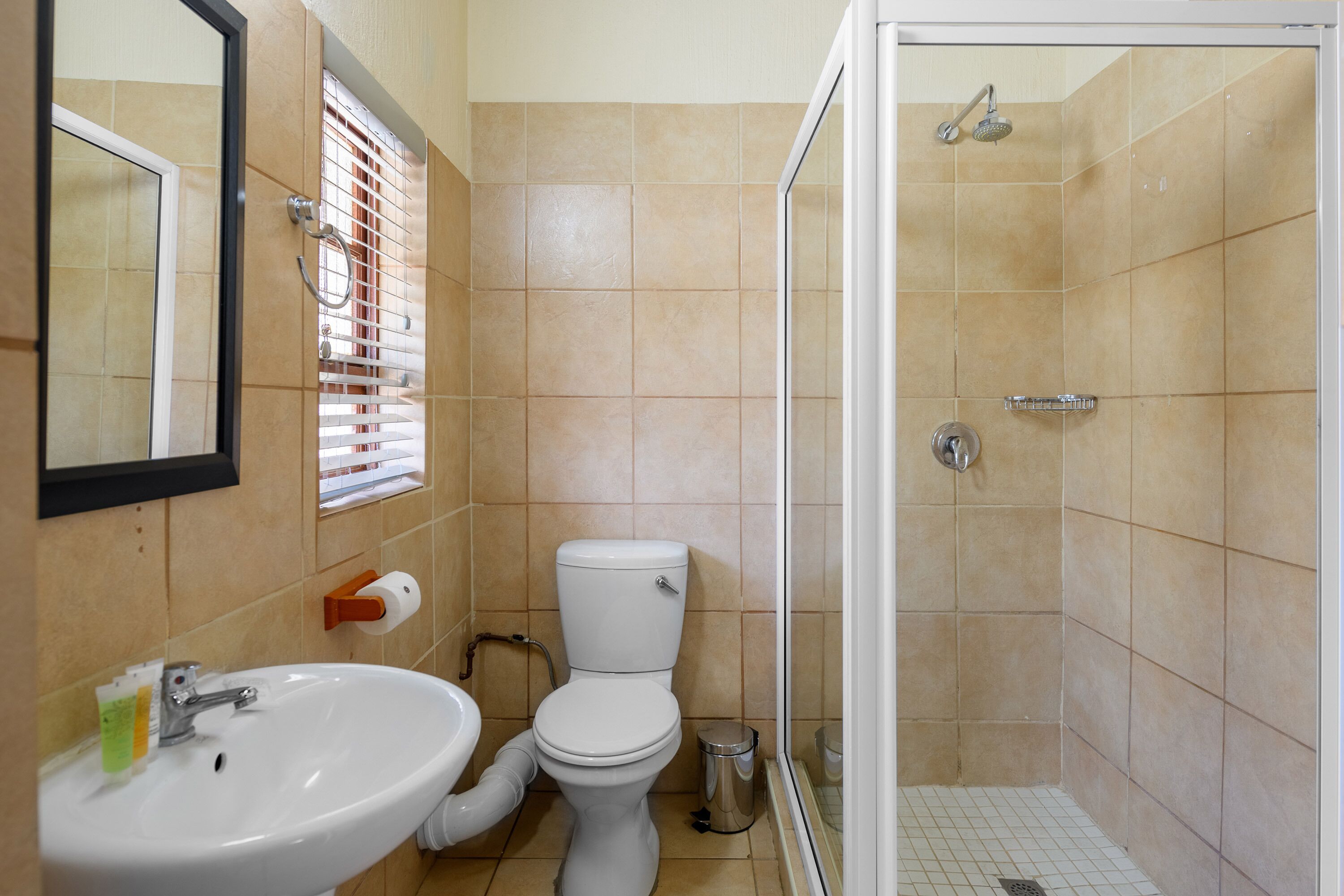 A bathroom with a sink, toilet, and shower.